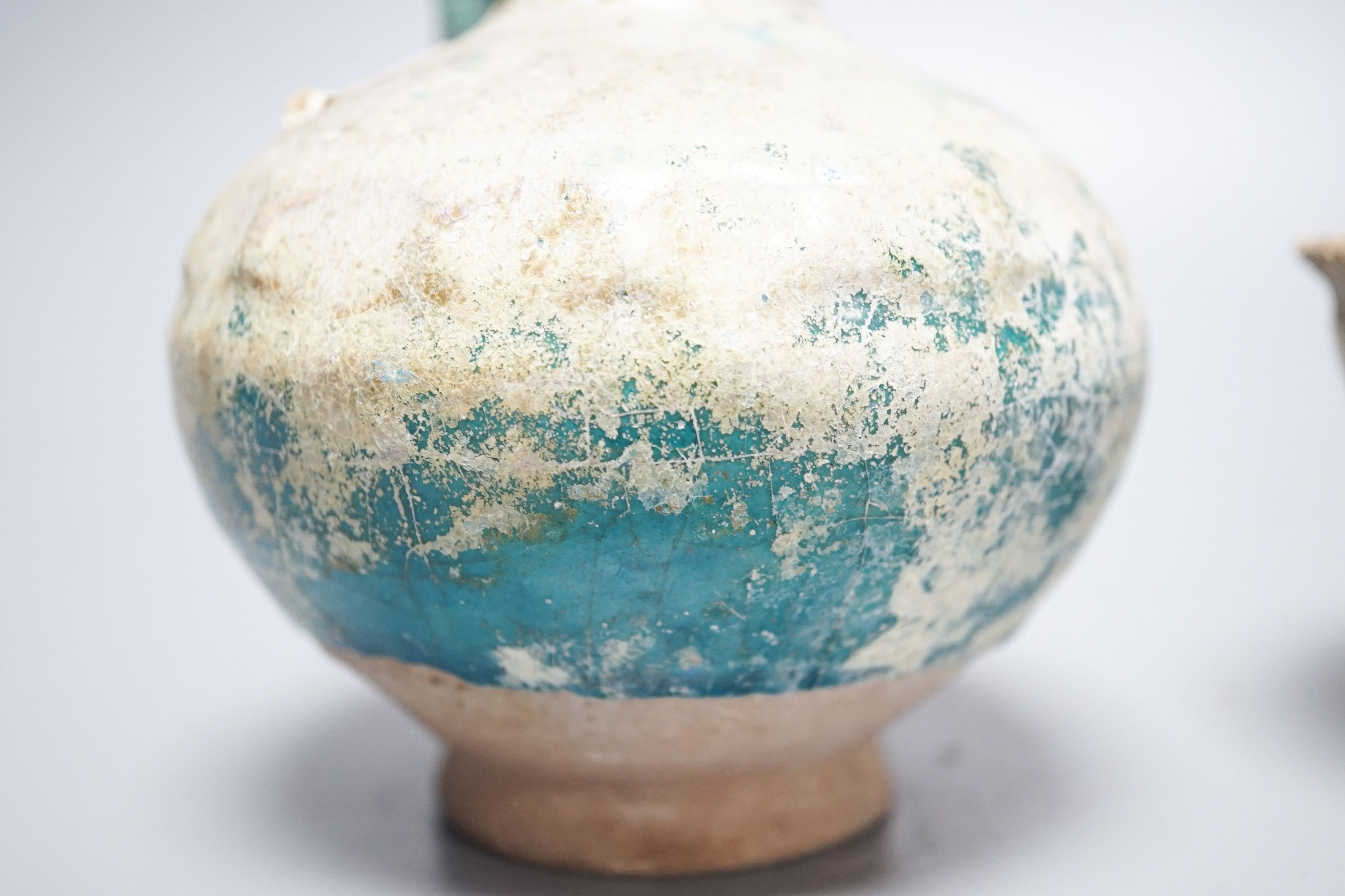 A Kashan turquoise glazed pottery ewer, 14th century, with mineral iridescence and an early Islamic pottery cup 14cm